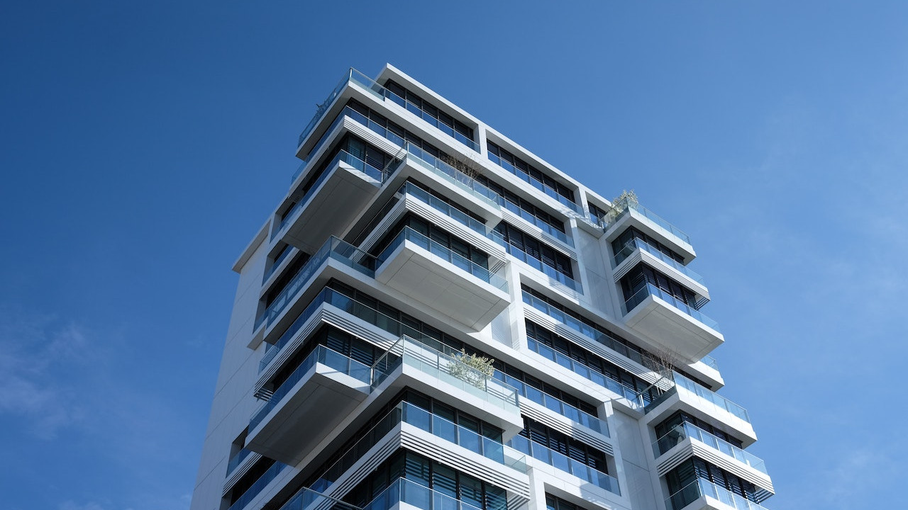 Ein modernes Hochhaus vor blauem Himmel: ENIANO bietet Lösungen für mehr Gebäudeeffizienz in der Bau- und Immobilienwirtschaft